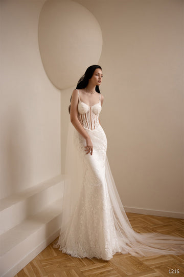 Woman wearing a white lace corset wedding dress with a long tulle veil