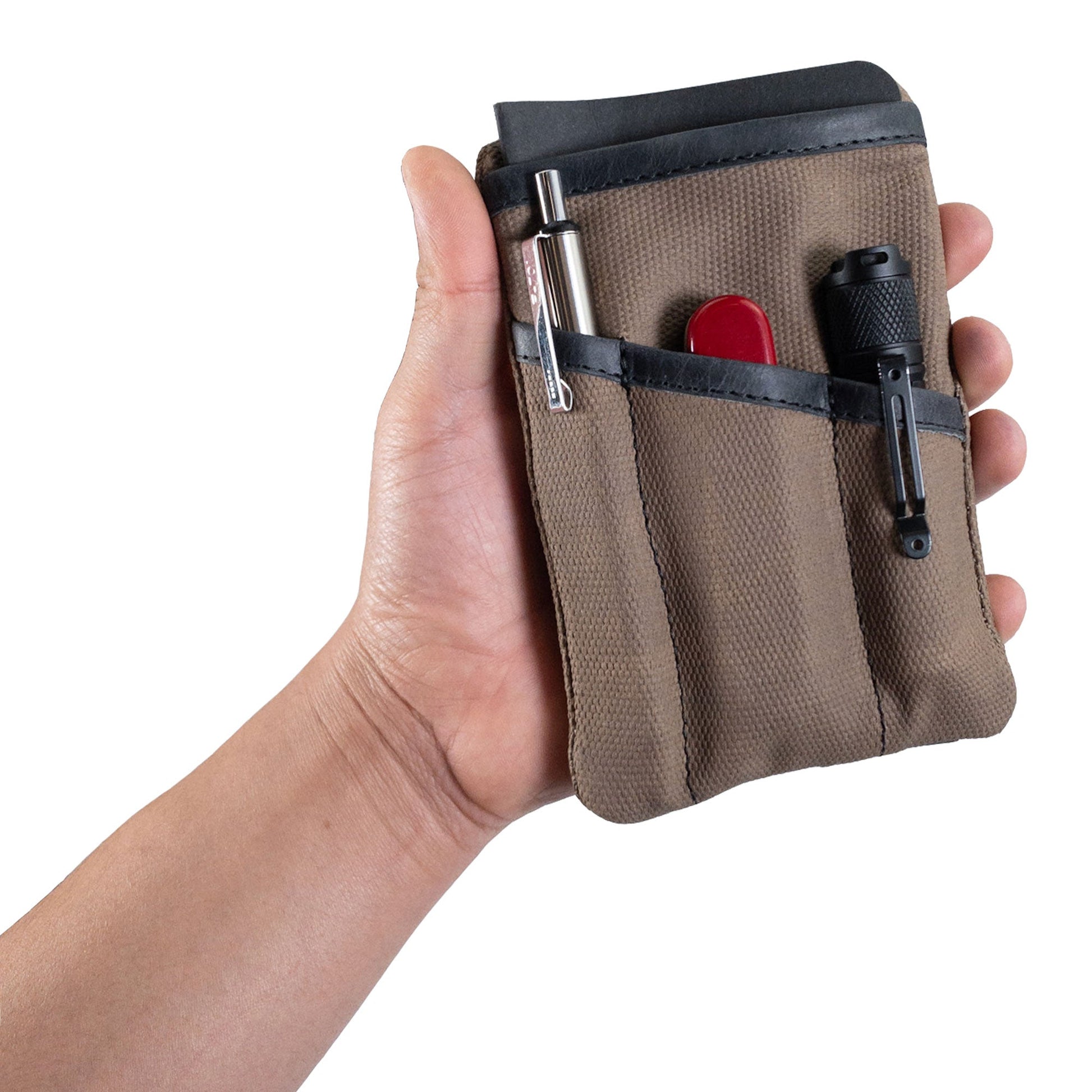 Person holding the khaki Multi-tool Pocket Pouch by Hide & Drink, showcasing its artisan design and effectiveness in organizing essentials.
