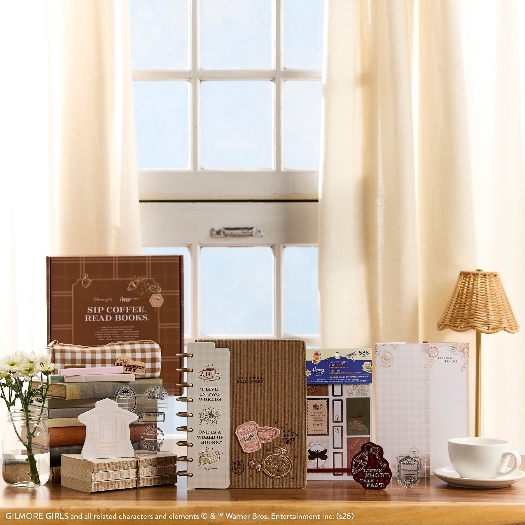 Gilmore Girls - Be Happy Box featuring a disc-bound planner with coffee and book-themed stickers, guided journal pages, and decorative accessories styled on a wooden table by a window.