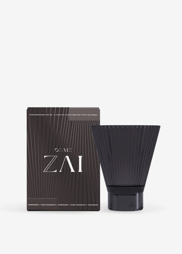 Black cylindrical container with ribbed design next to its packaging on a white background