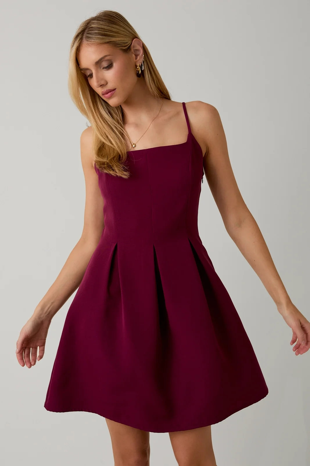 Woman wearing a burgundy dress against a plain background