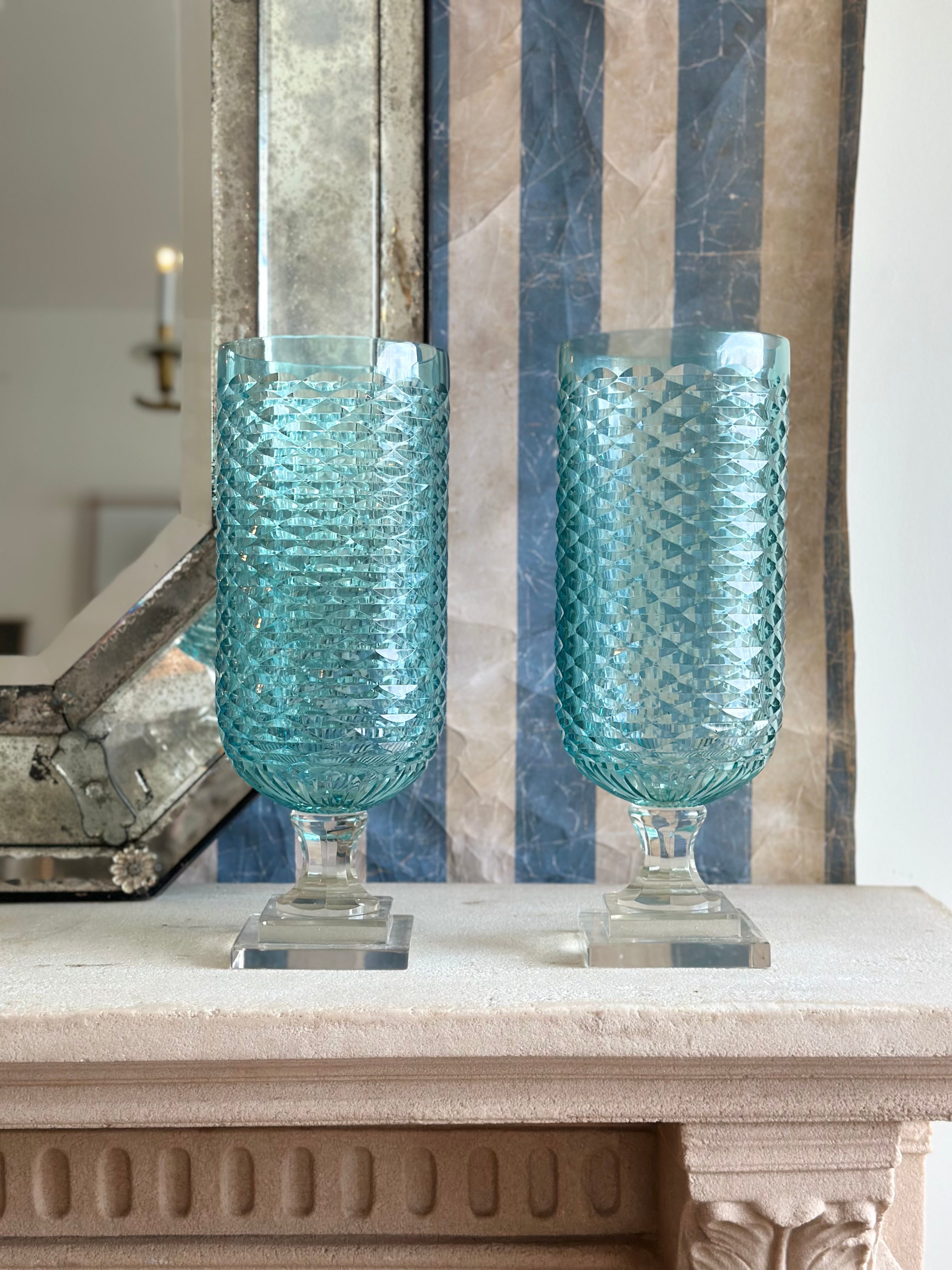 Pair of pale blue diamond-shaped hurricane candle holders from Housebound Interiors, featuring elegant, geometric design.