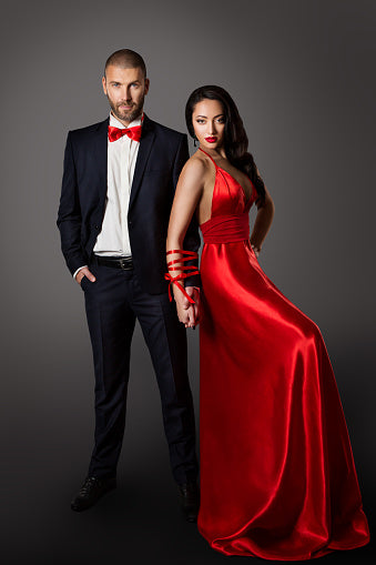 Fashion Couple Woman Red Dress And Man In Black Suit Hands Bounded Studio Portrait Stock Photo - Download Image Now