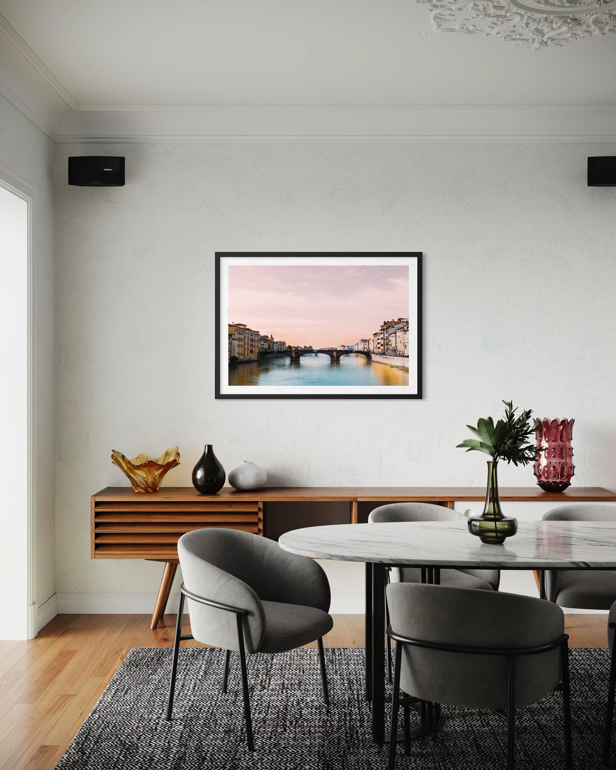 Dining room with a framed picture on the wall, wooden table, and chairs.