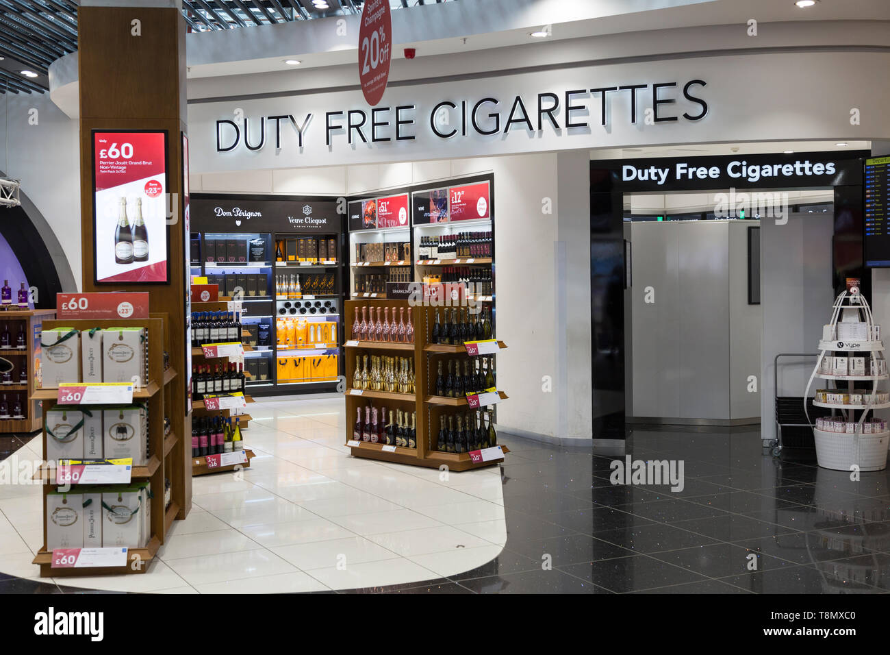 Inside the Duty Free shopping area at Stansted airport showing the screened off section for duty free cigarettes and display of bottles of alcohol Stock Photo