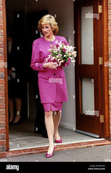 Princess Diana wearing pink suit holding bunch of flowers Stock Photo