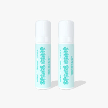 Two Space Camp Frosted Mint organic lip balm tubes with mint green labels and white caps on a light blue background.